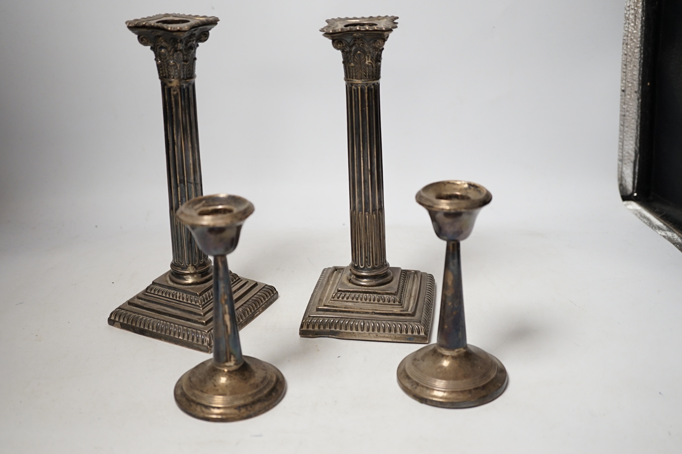 A pair of late Victorian silver Corinthian column candlesticks, Hawksworth, Eyre & Co, Sheffield 1896, 22.5cm, weighted (a.f.), and a smaller pair of silver mounted candlesticks.